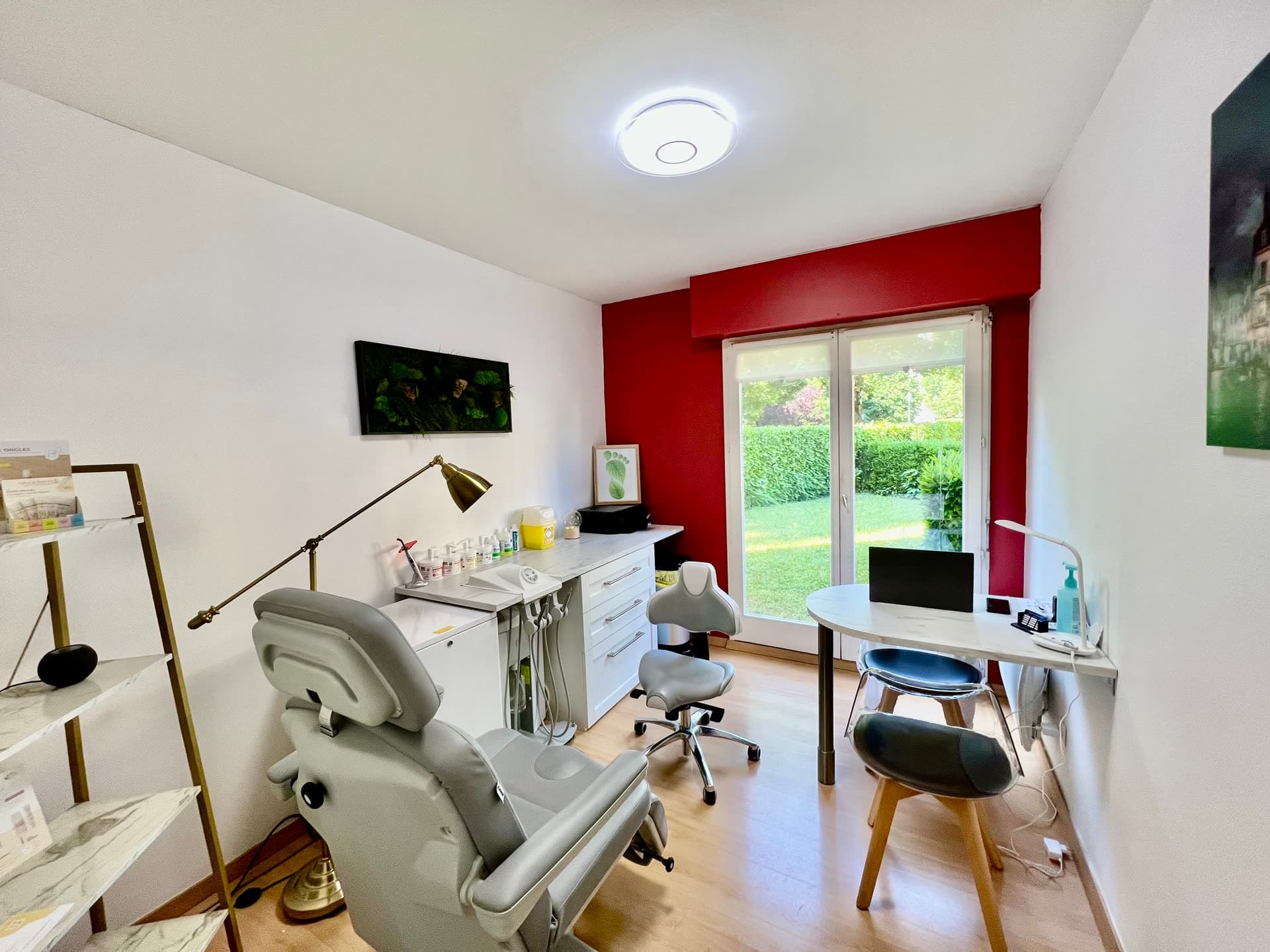 Salle de soins du cabinet de podologie à Dijon : fauteuil de pédicurie-podologie, poste de travail et baie vitrée donnant sur le jardin